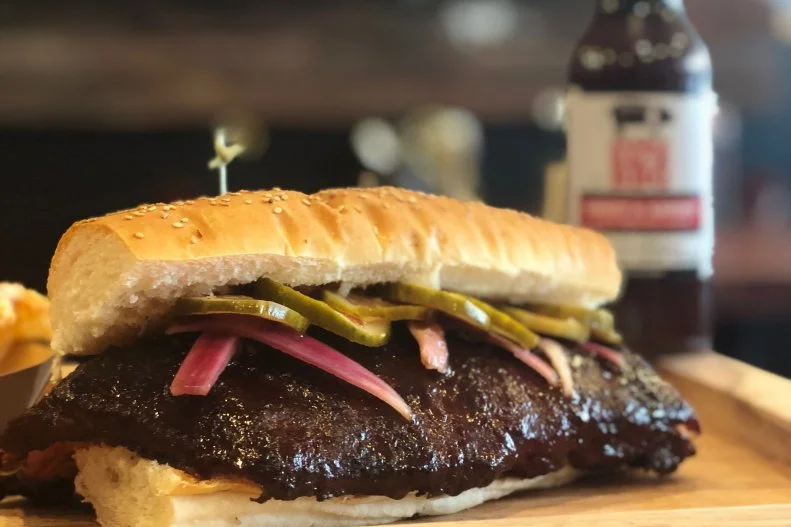 “This pound-and-a-half sandwich puts the McRib to McShame,” says Drew Piotrowski of Saddleback BBQ. This hulk of a hand-held meal starts with the smoker. The crew at Saddleback cook their baby back ribs for four to six hours in a blend of Michigan hardwoods (white oak, cherry, apple and a touch of hickory). When it's all nice and tender, they debone half racks, place each one on a bun and add housemade pickles and onions with a coating of sweet and savory barbecue sauce.