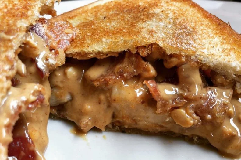 Some people think that Elvis Presley was the only one obsessed with fried peanut butter-and-banana sandwiches, but that sweet and creamy combination is actually a regional specialty across the Mississippi Delta. One of the best versions in the area is served at The Arcade in the King’s home base of Memphis, Tennessee. There, thick Texas toast is smothered with peanut butter and about half a sliced-up banana. The cooks add a good amount of butter to the griddle and fry up the sandwich until the edges of the bread's crust begin to brown. While they do serve a simple vegetarian version, many guests choose to add bacon to make the dish even more flavorful and filling.