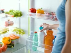 Woman taking a bottle of fresh milk from the fridge, nutrition and diet concept