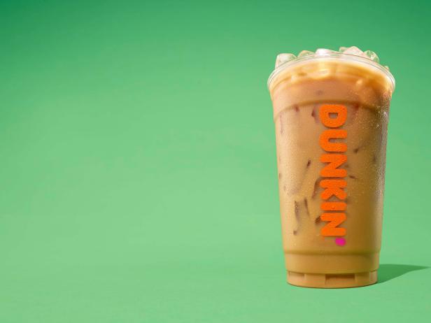 2019 Q1 (March) POS element mechanical background image: Mini DTE - Irish Creme flavored Iced Coffee (hero angle), in branded plastic cup - green background