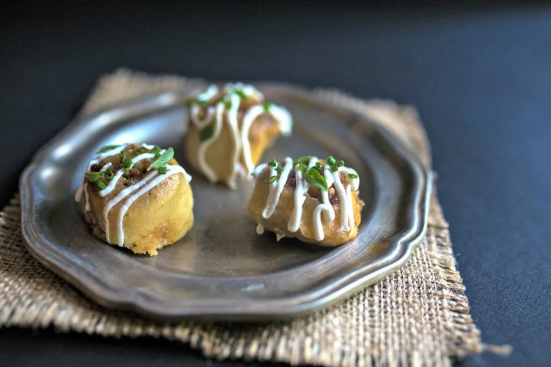 In Charlotte's modern Uptown neighborhood, the historic Dunhill Hotel manages to blend Old World charm with modern amenities. That contemporary sensibility extends to the hotel's restaurant, The Asbury (named for named for the hotel's architect, Louis Asbury Sr.), which even has its own hashtag, #bodybybiscuit. The Southern staple, baked by pastry chef Miranda Brown, shows up in the can't-miss sticky biscuits (pictured), a sweet-savory bite starring biscuit dough rolled with 14-month Benton's Country Ham and brown sugar and drizzled with goat cheese icing; cast-iron baked biscuits with bacon jam; and brunch-ready ones served with sawmill gravy. The latter is a particularly fine option if you're planning to go all in on brunch with pitchers of mimosas, or if you've had one too many cocktails in the bar the night before. That's easy to do — the bar's ambiance is cozy, and the drinks, overseen by bartender Brett Leek (who worked at the lauded Punch Room under Bob Peters), are as clever as they are balanced. Outside of the biscuits, Executive Chef Mike Long shows his range with reinterpreted Southern fare like pork cheeks with an apple and mustard demi-glace, and seasonal vegetable dishes like a grain salad with whipped local ricotta, roasted beets, pistachios, house-pickled carrots and a preserved-lemon vinaigrette. Save room for one of Brown's seasonal desserts, such as white chocolate and fennel panna cotta with apple and fennel relish. You can pick up edible souvenirs, find local beers on tap or do a wine tasting at 7th Street Public Market, a few blocks away.