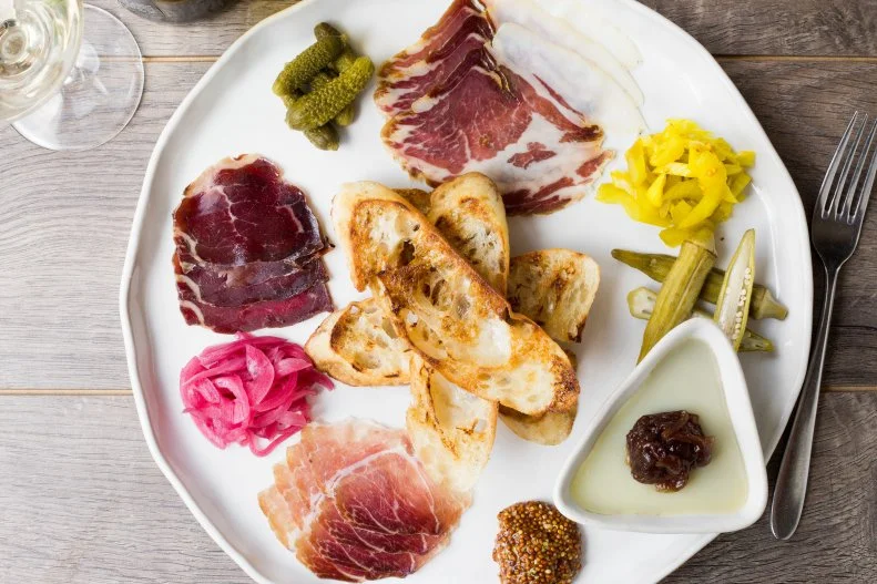 Mandolin is the definition of a neighborhood gem — you're just as likely to turn to it to cure a case of the Mondays with a burger as you are to celebrate a special occasion with a three-course dinner. The space evokes a cozy farmhouse-chic charm, the service is always on point, and Chef Sean Fowler's cooking seamlessly blends fine-dining technique with classic Southern dishes, many crafted with produce from his own farm. The mix-and-match bar specials menu is also one of the best deals in town, making a good case for stopping in often. For $15 you can pair a craft beer with dishes such as a pimento cheeseburger or pulled pork barbecue sliders, and snacks like housemade pork rinds and collard ranch, which gets a tart-funky punch from smoked, fermented collard stems. Whether you dine at the bar or in the main dining room, don't miss the gold-standard charcuterie plate, featuring staples such as a lush chicken liver pâté and head cheese served with grilled toast, grainy mustard and seasonal pickled veggies like homegrown cucamelons or okra. Other menu standouts include an off-menu, wood-fired bone-in rib eye, and the fanciest chicken and waffle in town, finished with a bacon-mushroom emulsion and a truffle honey drizzle. Whether or not you've got room left, have at least one bite of the swoon-inducing chocolate souffle, made with 70% Guatemalan chocolate from Raleigh's Videri Chocolate Factory.
