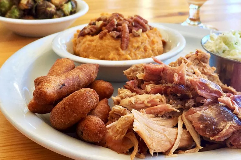 According to Picnic's co-owner Wyatt Dickson, any barbecue restaurant must do five things right to succeed: The barbecue, sauce, coleslaw, sweet tea and banana pudding must all be on point. Dickson, along with Ryan Butler and Ben Adams, is nailing it. In North Carolina, barbecue means pork, and Picnic specializes in whole-hog barbecue. The pigs are sourced from Butler's Green Button Farm, located 10 miles down the road, are slow-smoked over wood and coals in a custom-built smoker and are then pulled apart by hand. The succulent shreds are judiciously sauced with Dickson's Pig Whistle, an Eastern-meets-Western North Carolina barbecue sauce â   that is, vinegar-based amped up with Texas Pete hot sauce and "a little red" (typically ketchup in the western part of the state). The barbecue is served as part of a plate or on a sandwich, both of which come with excellent slaw that is neither too creamy nor too vinegary. A plate also comes with two scratch-made sides, such as mac 'n' cheese, bacon-braised collard greens and sweet potato puree topped with spiced pecan crumble. (If barbecue just isn't your thing, there's also a stellar fried chicken sandwich.) Wash it down with a glass of sweet tea â   the signature iced tea of the South is brewed fresh throughout the day here, and is not too cloying â   and be sure to save room for the banana pudding.
