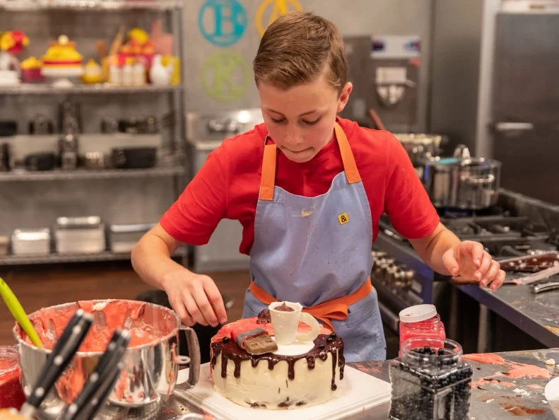 Contestant Davis Sams decorates his cake during the main bake, as seen on Kids Baking Championship, Season 6.