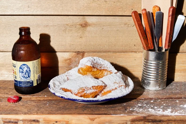 These golden freshly fried beignets arrive at the table covered in what feels like a kilo of confectioner’s sugar. In fact, you might have to do some exploration with your fork just to confirm there are in fact doughnuts below the sugar blizzard. There are. And when you bite in to those beignets, you inhale a yeasty perfume and regard the delightful contrast of the crisp exterior and the bubbly soft threads of the interior. You might even convince yourself they’re better than the ones served at New Orleans’ famous Café du Monde