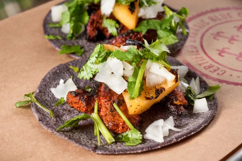 While this style of tacos originated in central Mexico, the flavor combination of grilled pineapple and achiote-marinated roast pork has been enthusiastically adopted by Miami’s taco-eating crowds for its Mexican-Caribbean and coastal South American flavor profiles. Rich and a little bit fatty and vinegary-peppery from the achiote, with pineapple sweetness, these tacos are wildly appealing. They’re almost always made on soft corn tortillas; Taquiza raises the bar with its specially light and chewy blue corn tortillas stone-ground from blue corn masa.