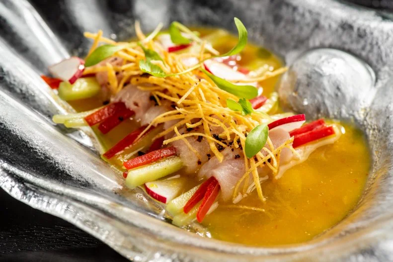 Tiradito is a Peruvian raw fish dish that can take you on some unusual flavor adventures. Typically you find it in a Peruvian-Japanese restaurant. (There are many of these — Japanese immigration to Peru strongly influenced Peruvian food.) However, Miami is always game for a tasty culinary crossover, so tiradito has been embraced as sushi’s Latino cousin. It features sushi-grade raw fish cut like sashimi — thin slices, not chunks — and served in a sauce or dressing. It might be simply lime-based like ceviche, or it might be a pepper cream or include olive oil.  Some of the most exquisite tiradito in Miami is at Richard Sandoval’s downtown stunner Toro Toro. He wraps hamachi around a little bundle of julienned peppers and other veg, then arranges the bundles in a marinade of habanero-passion fruit aguachile for a triple punch of sour, sweet and fiery — with cilantro oil for smoothness.