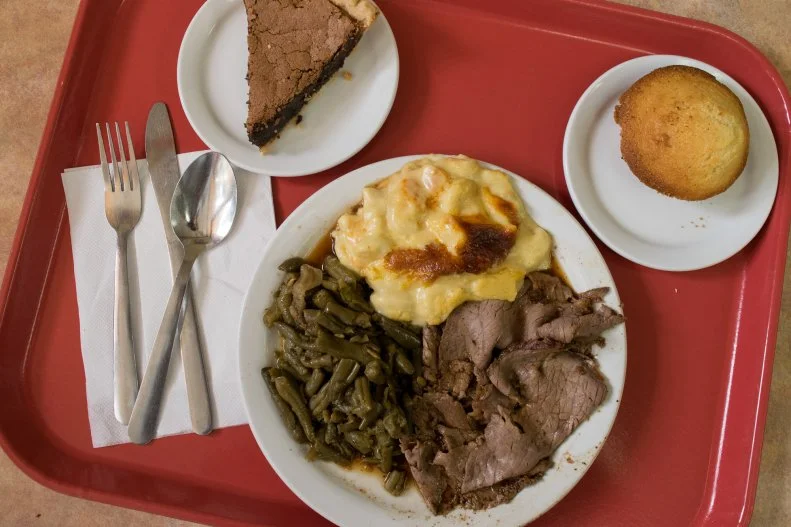 The truest taste of Nashville can be found on a red tray at Arnold’s Country Kitchen. Since 1982, it’s stood as one of city’s most beloved meat and threes — a place where you can get an affordable, filling, Southern midday meal of a protein and three side dishes, plus a drink and dessert, served cafeteria-style. It’s still run by the Arnold family, including mom Rose and son Kahlil, who offer up some of the city’s warmest hospitality. As you walk down the serving line, you’ll choose from-scratch staples like roast beef, meatloaf and fried catfish, to go along with sides like long-cooked turnip greens, fried apples and mac and cheese.