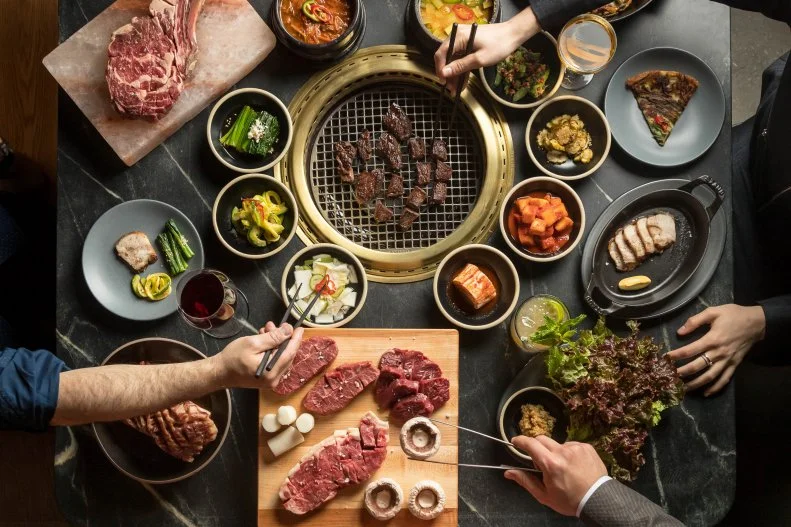 Restaurateur Simon Kim blends Korean barbecue with the American steakhouse at Cote, a Michelin-starred Manhattan hotspot. The lively restaurant is hailed for its in-house dry-aging program that features a selection of USDA Prime and American wagyu cuts, some of which are hung for more than 110 days. Guests can order ribeyes, New York strips and porterhouse steaks, but the specialty here is chef David Shim’s prix fixe Butcher’s Feast that includes a smorgasbord of four cuts cooked on smokeless grills embedded in each table with a spread of seasonal Korean sides known as ban-chan. Cote’s acclaimed beverage director Victoria James pairs the meaty selection with an array of artisanal soju, wines by the glass poured from giant magnums and an extensive bottle list.