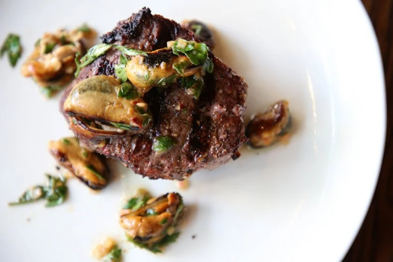 This modern steakhouse in the midst of Seattle’s South Lake Union serves a rotating seasonal menu that highlights Mishima Reserve American wagyu beef. That luxurious meat is served in creative dishes like Pacific Northwest Surf & Turf, topped with house-smoked Penn Cove mussels and a salsa verde of shallots macerated in lemon juice, brown rice miso, garlic, chile and parsley. The two-story space includes a livelier street-level lounge decked out with mahogany and leather-bound chairs as well as a bar serving craft cocktails. Downstairs, the intimate dining room offers a more romantic vibe lit by candles and the cozy glow of the fireplace.