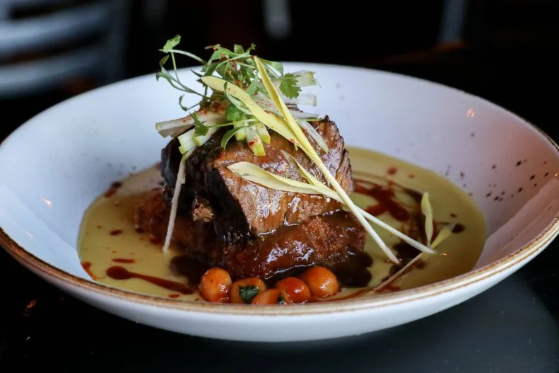 Humbly tucked in a Southwest Las Vegas-area retail strip mall, The Black Sheep is the brain child of chefs Jamie Tran, Andy Hooper and Jon Schwalb, who successfully fuse Vietnamese-American flavor profiles with comfort classics. Plates are pretty and plentiful. Take, for instance, bao sliders, which stand tall layered with a fried quail egg-topped pork sausage, mild crispy shallot, fragrant herbs and sharp jalapeño aioli on house baos. With the Black Sheep hot chicken, the spicy protein is kicked up a notch with the addition of honey mustard seed and pickled cucumber on a plate of honey toast. This restaurant may be “the black sheep” of the retail strip, but it’s putting all the fun back into classic eats.
