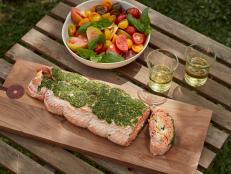 Celebrate the summer season with this grilled side of salmon, perfect for a crowd. Stuffed with creamy sweet corn and slathered with a bright green herb butter, it is as beautiful as it is delicious.