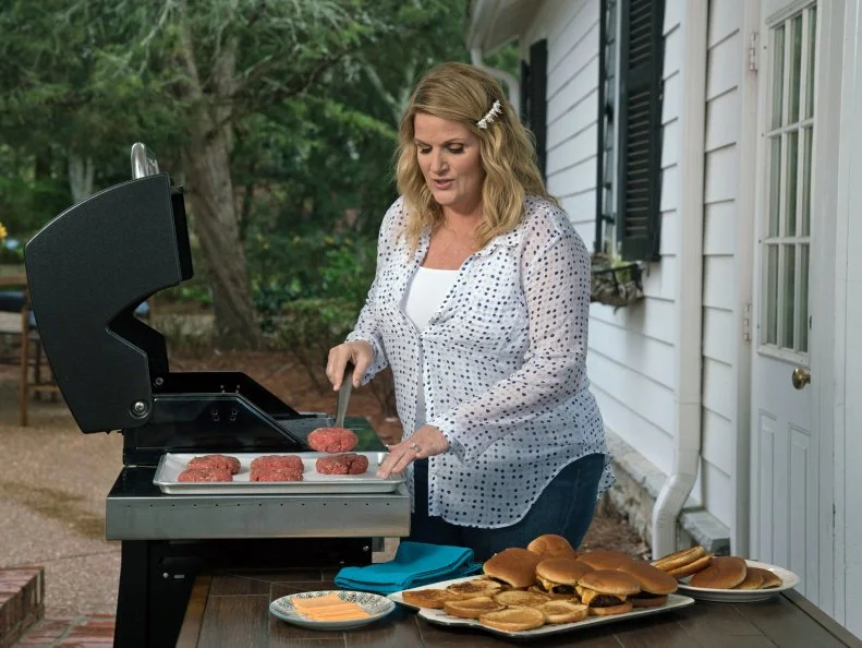 Wide shot of Trisha grilling hamburgers, as seen on Trisha's Southern Kitchen, Season 12.