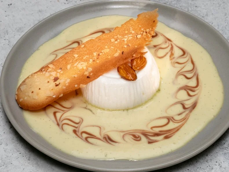 Contestant Jeffrey De Leon's dish is Traditional isle flottante with vanilla angles, caramel ganache and almond langue de chat, during the Skills Challenge, as seen on Best Baker in America, Season 3.