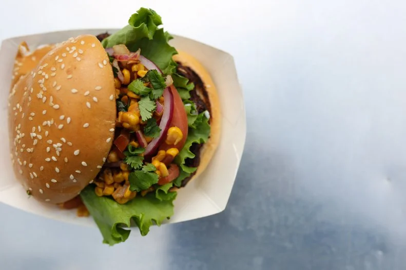 Dave Barry is a proud Iowan, so it should come as no surprise that locally sourced ingredients are a priority for Top Bun, his Des Moines-based burger truck. He sources local beef, local buns and hoagie rolls, and Italian sausage meatballs from renowned Graziano Brothers for his USS Torpedo, a meatball-, red sauce- and provolone-stuffed hoagie. On the burger front, try the fan-favorite Flyin’ Hawaiian, a seared one-third-pound patty stacked with grilled pineapple, roasted red peppers and teriyaki mayo. Pair with an order of Truffle Shuffle Tots, fancy potato tots tossed in truffle oil and Parmesan with a spicy mayo drizzle. Barry uses the tots to finish the Captain Coyle (pictured above), a black-bean veggie burger topped with roasted corn salsa and cucumber ranch. You’ll find the truck’s schedule updated on its website — local office parks, the State Capitol complex, and the Pappajohn Sculpture Park downtown are all favorite hangs — but you can also place orders online for a specific pick-up time to skip the line.