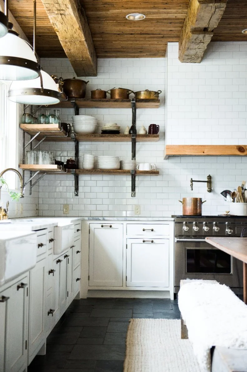 Rather than upper cabinets for wall storage, designers opted for open shelving that was crafted out of materials that were repurposed from the home's original kitchen. 