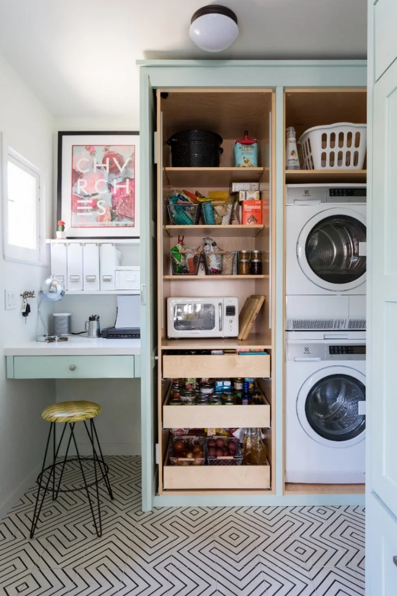 Because this galley kitchen is smaller in scale, it was important to utilize every square inch. Thus, designer Lucie Ayres tucked her clients' washer and dryer behind some custom cabinets and gave them drawers for a little pantry area as well.