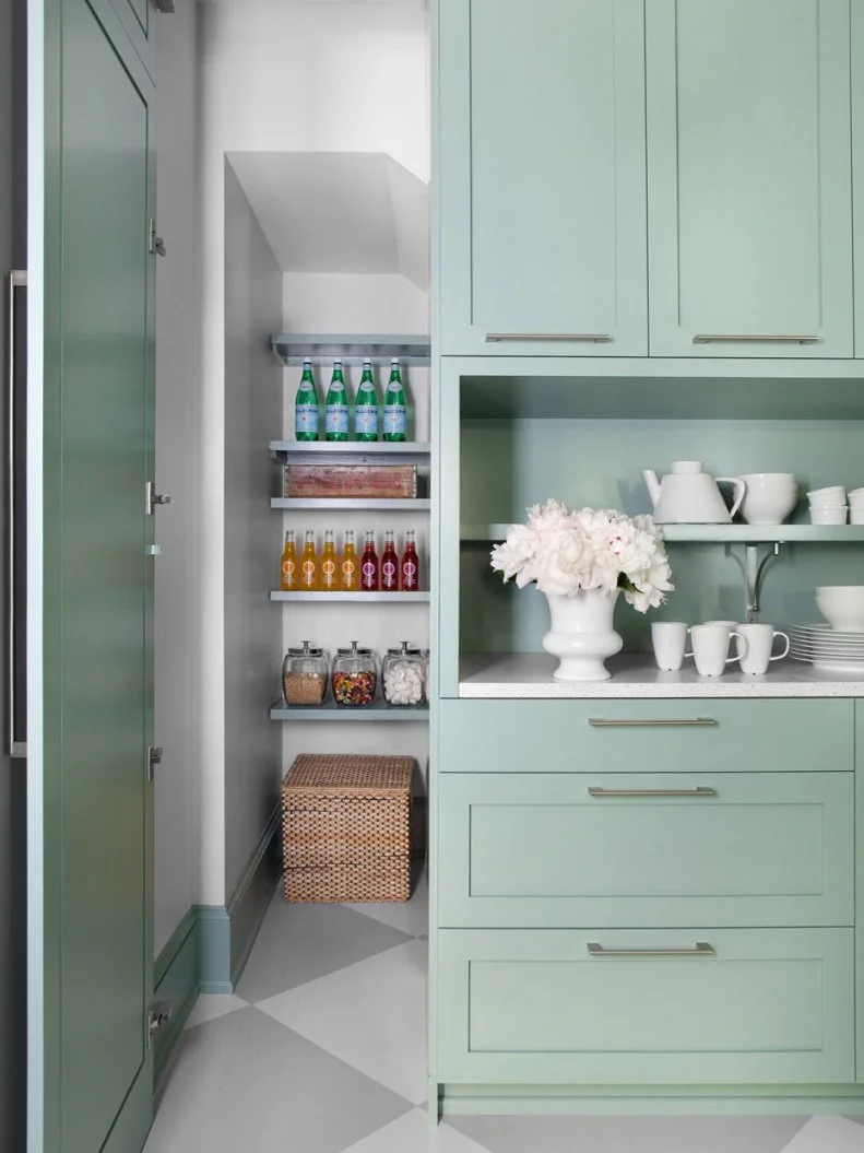 What looks like a door to a simple cabinet opens up to reveal a secret walk-in, closet-sized space that increases the storage capacity of the room.