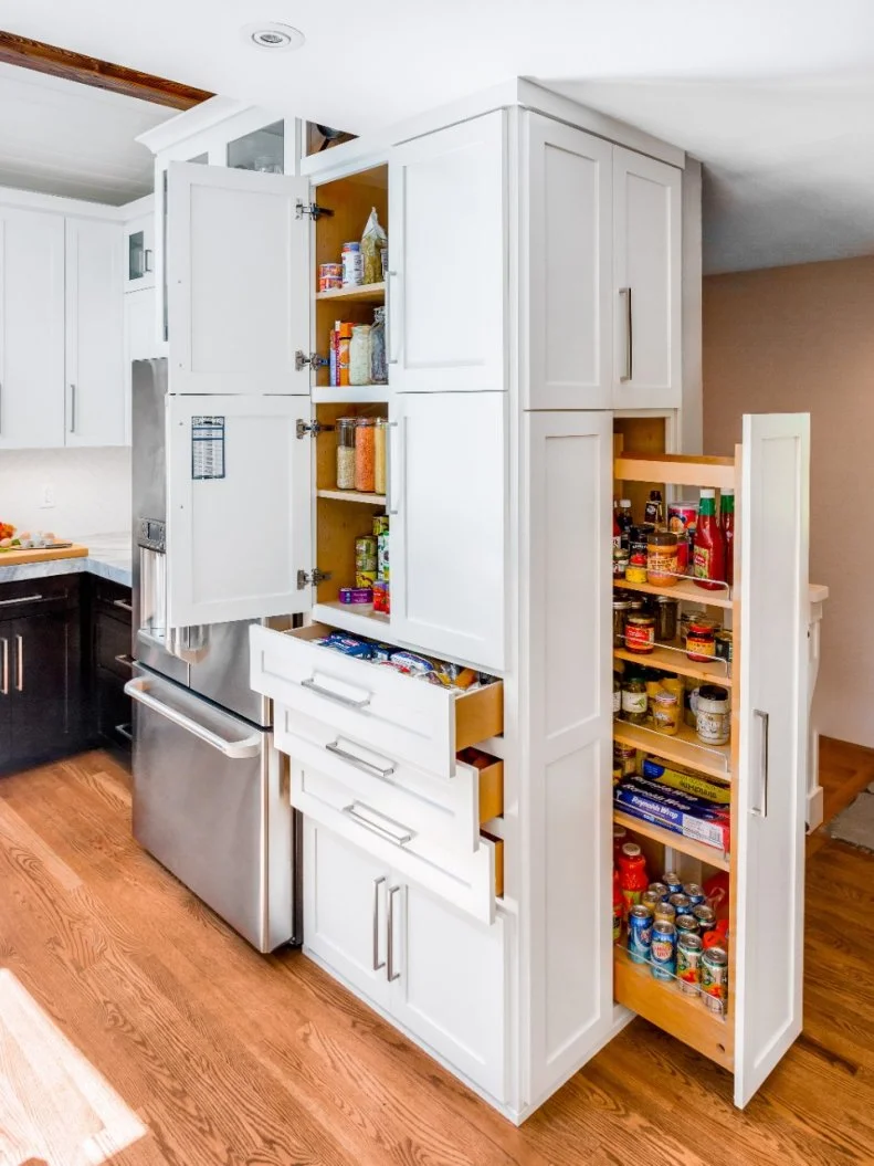 A custom pullout pantry creates extra storage space in this contemporary kitchen. Plentiful drawers and cabinets help stow away other essentials while keeping them close at hand.