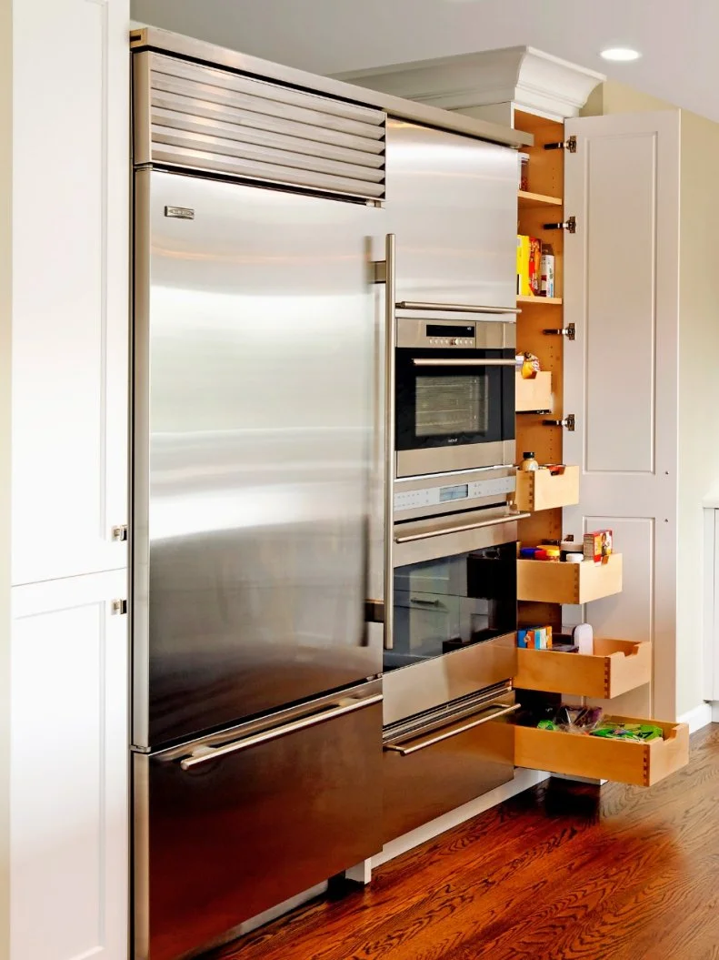 A refrigerator, oven and wine cooler fit into a compact area to maximize space in this small kitchen.
