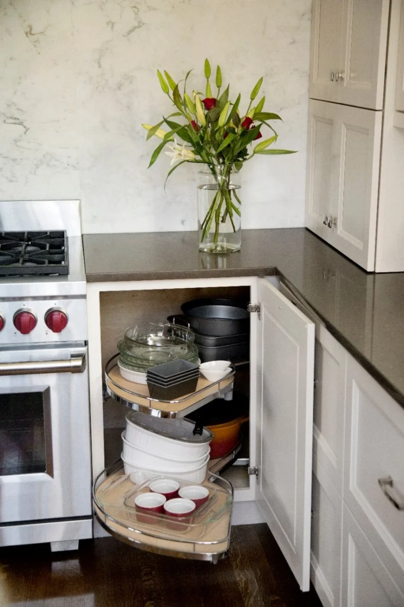 To create a functional cabinet out of those difficult corner cabinets, designers added two custom, pull out shelves. Not only does this double the usable space in the cabinet, it puts all of the homeowners gadgets within reach, creating a storage solution that truly makes life easier. 