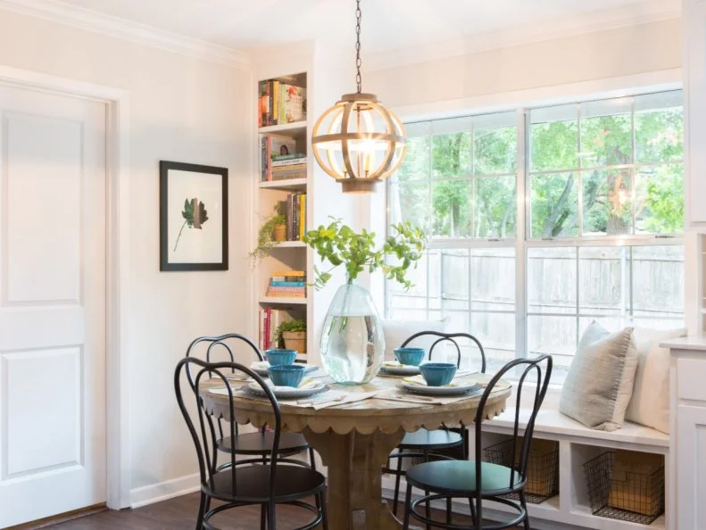 A rustic pedestal table, chandelier and contemporary chairs create an ideal breakfast nook and a place for serving kids' meals.