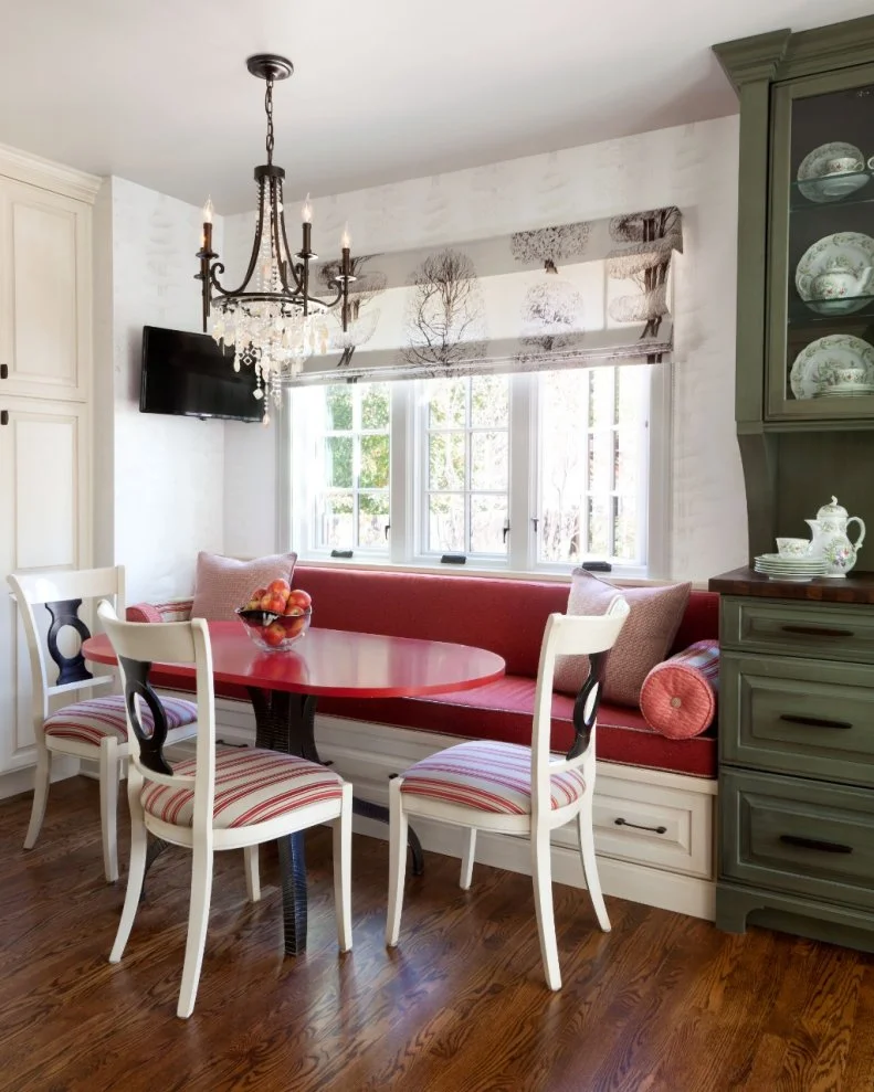 The colors and patterns take this traditional breakfast nook in a decidedly contemporary direction. Red gives vibrant punch to the banquette and table. Drawers beneath the bench provide handy hidden storage.