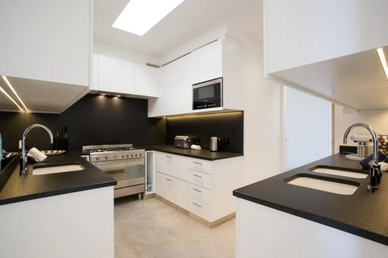 Black and white makes for a dapper, crisp statement in the kitchen (one of two in the home) with its chef's grade range and ample cabinet room.