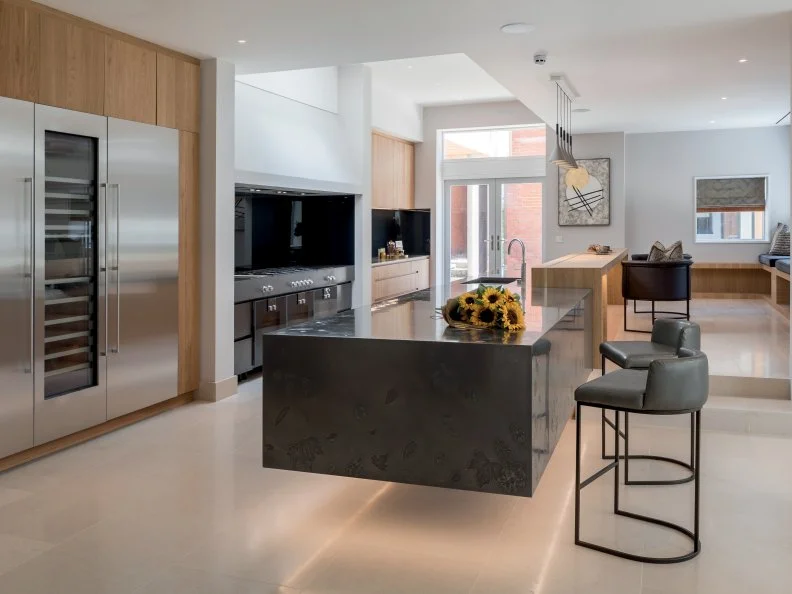 Clean, simple lines and black accents give this open plan kitchen all the sophistication of a three-star restaurant. Chefs would approve of the bespoke Gaggenau range.