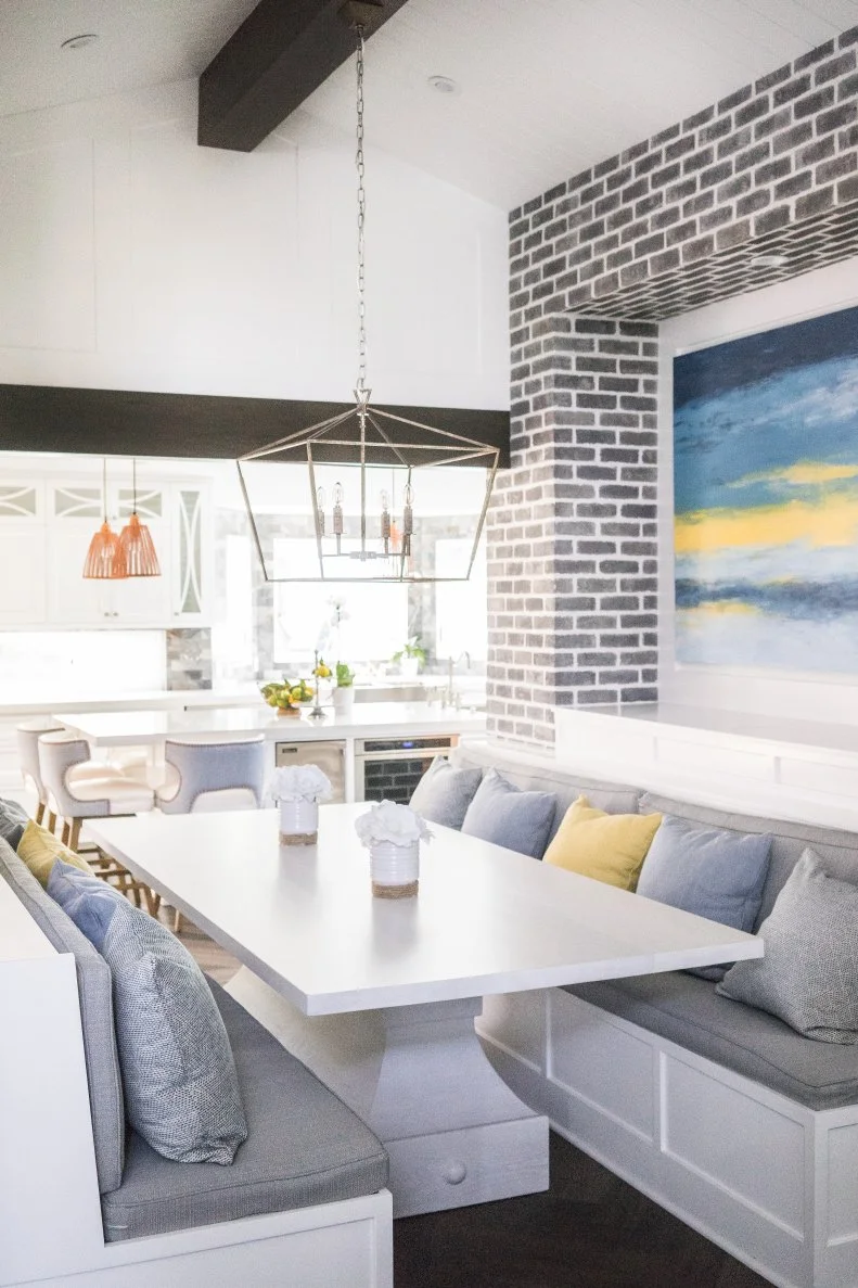 This breakfast nook with built-in benches and an exposed beam opening creates a destination within the large kitchen. It also creates extra seating space without taking up too much square footage.