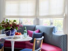 Just like the family room, this breakfast nook features bright pops of pink and blue. A large banquette and two cushioned chairs ensure that everyone feels comfortable as they gather 'round the table. 