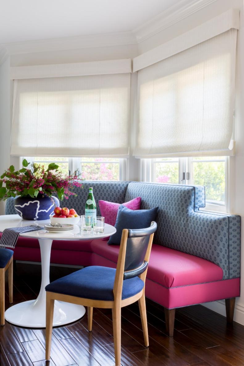 Just like the family room, this breakfast nook features bright pops of pink and blue. A large banquette and two cushioned chairs ensure that everyone feels comfortable as they gather 'round the table. 