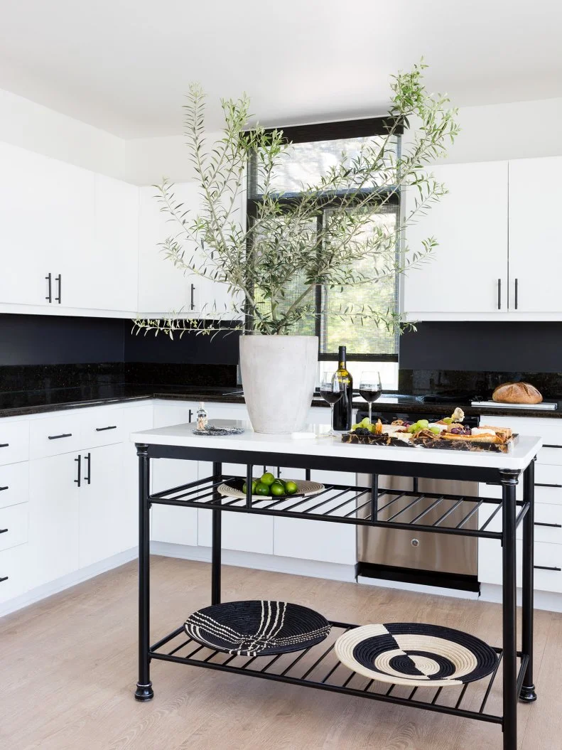 This modern kitchen has it all: stainless appliances, ample counter space, a small island and a breakfast nook right around the corner. Glossy black subway tile brings some sleek texture to the room as well. 