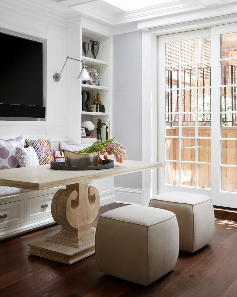 This breakfast nook features plenty of natural light and a built-in bookshelf. The bench seating allows for a perfect gathering space for family breakfasts. 