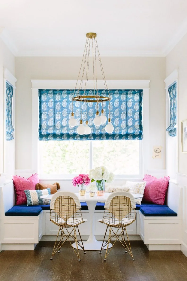 Mornings automatically feel more cheery in this colorful breakfast nook where blue paisley shades and cushions and pops of bright pink welcome the day with style. Gold accents are a sophisticated finishing touch.