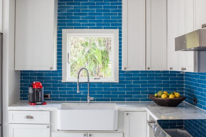 The kitchen of this home needed to have character like the rest of this vintage home so designers added bright, bold colors and mixed shiny, smooth textures with vintage favorites. The bright blue backsplash was one of the flashy, glamorous pieces and by mixing that with more traditional cabinets, the space gets a touch of the old world and the new. 