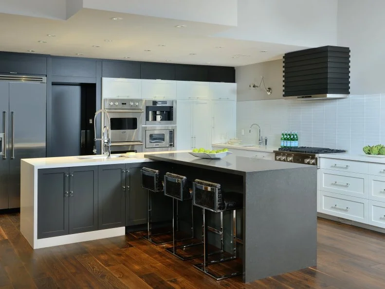 This kitchen, which won First Place in large kitchen category at NKBA Ontario Design Awards in 2013, uses an L-shaped floor plan and T-configured center island to maximize space, and to create a sleek, masculine look.