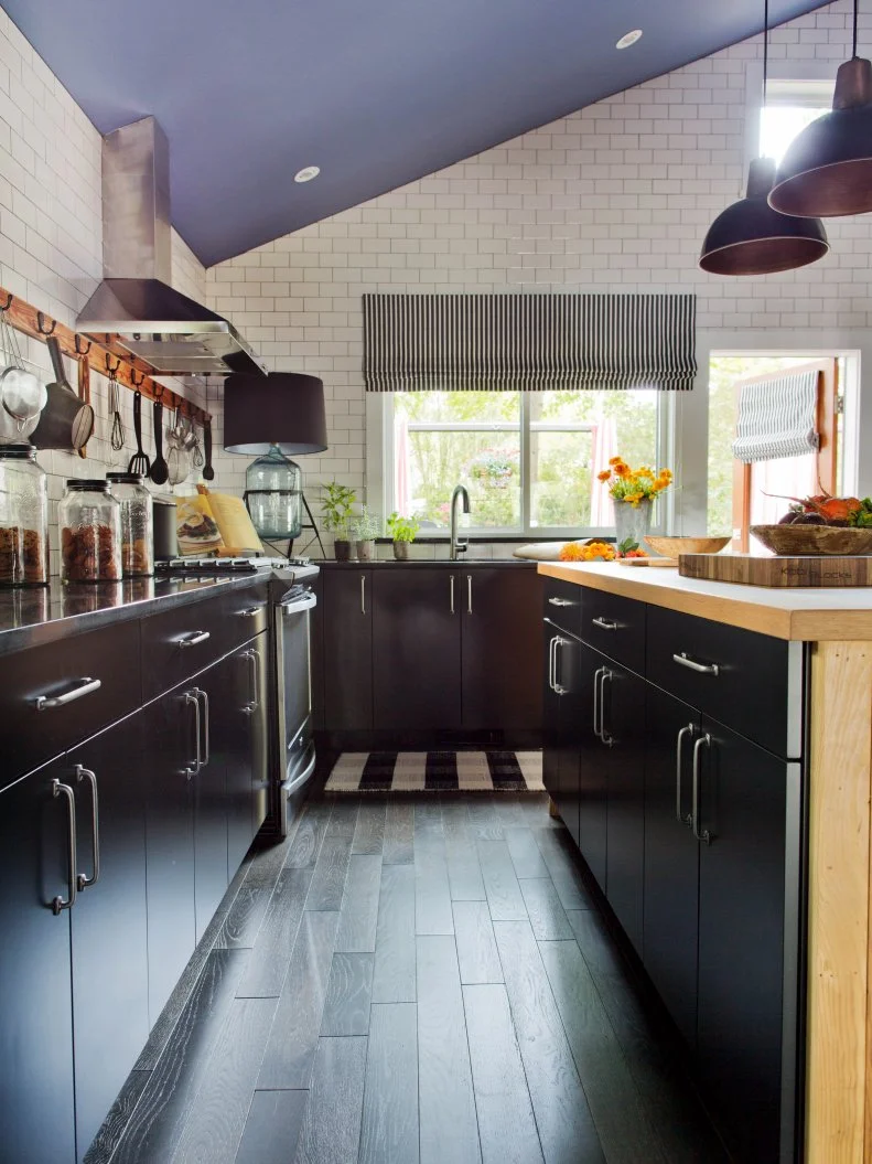Black cabinets provide a dramatic contrast against bright white subway tile for a classic color combination.