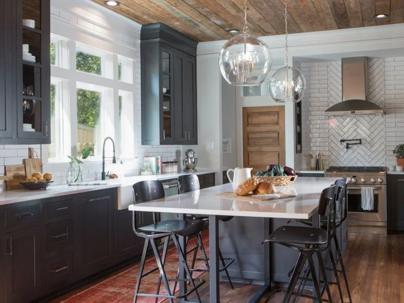 As seen on Fixer Upper, this newly renovated rustic kitchen features a black and white island.