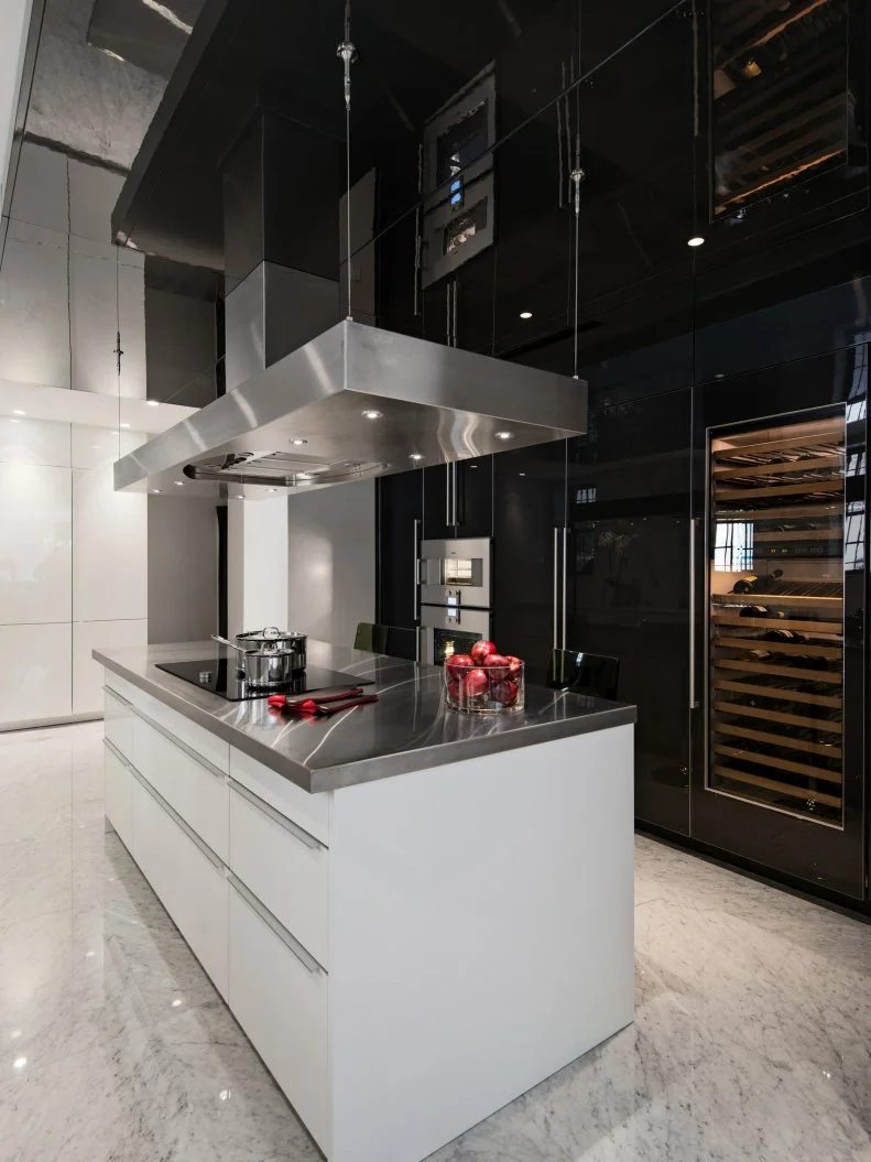 This sleek kitchen island gives the homeowner and his family plenty of space to create and enjoy their food. The size of the island not only gives the family space to enjoy each other and their culinary creations, it also adds plenty of space to conceal the high tech devices the family needs. 