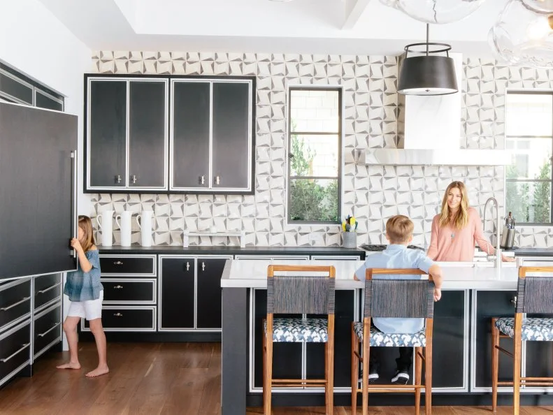This large-scale kitchen isn't shy about bold colors and patterns...with gorgeous results! Black cabinets and pendants are a sharp foil to the graphic accent wall and animal print barstools.
