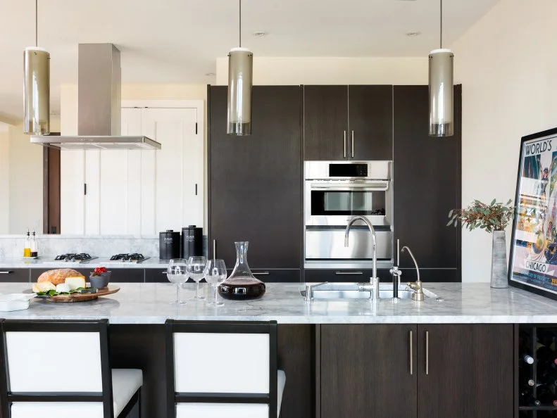 This contemporary kitchen has dark stained cabinets that contrast with the light cabinet and wall color. 