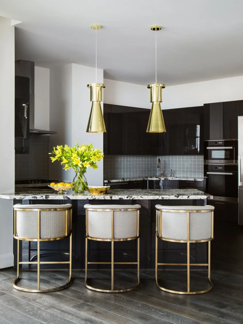 The dark base in this kitchen—black cabinets and appliances, gray backsplash—allows for bright pops of color and shimmery metallics. It's a sophisticated way to create a neutral foundation. 