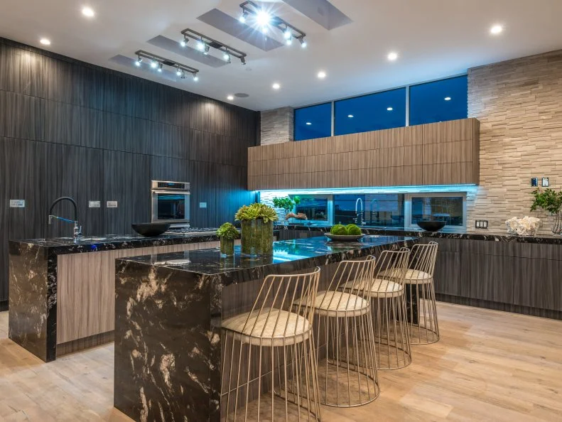 The fabulous cook’s kitchen is filled with natural light from the large windows and skylights. Double islands provide plenty of prep and work space, as well as a great spot for dining. Custom Italian cabinets allow for much-needed storage while creating a one-of-a-kind look. 
