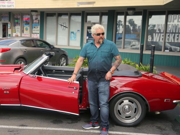Host Guy Fieri getting out of his Classic Chevy SS Camaro out front of Chuy's Taco Shop in San Diego, California, as seen on Diners, Drive-Ins and Dives, Season 30.