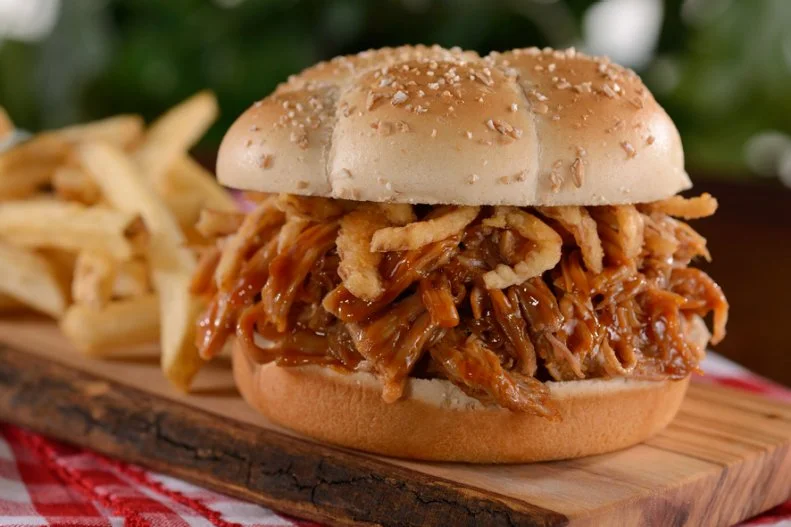 If you’re visiting Epcot to taste flavors from around the world, don’t even bother to peek at Liberty Inn, which is unabashedly all-American. But if there’s no talking you — or, more likely, your little ones — out of the foods they know so well, this fast-food favorite with a bright colonial feel will keep everyone content. The restaurant’s barbecue pork sandwich has a well-justified following, so join the hordes and give it a go. A fluffy brioche bun is topped with pulled pork slathered in a sweet and smoky sauce. Disney is mum about what that sauce is made of, but it’s irresistible. Together with battered and fried onion strips, the combo makes quite a lunch or dinner.