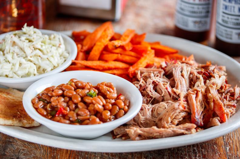 When passing through Tennessee, there's plenty of places for a meat and three pit-stop, but none quite like Puckett's. Originated in the '50s as a tiny grocery store in Leiper's Fork, the shop soon expanded to accommodate visitors’ requests for good barbecue in Franklin, south of Nashville, just off Interstate 65. The owners began smoking up low-and-slow meats, namely 18-hour Memphis-style pork that's so tasty it's become the star of the breakfast, lunch and dinner menus. Early risers shouldn't miss the Southern Stack, two sweet potato pancakes layered with pulled pork, fried apples, a sunny-side up egg, and home fries served in a skillet. The Piggy Mac with white cheddar cheese and biscuit crumbs is a close second for fan favorite. Since all that barbecue might glue you to your chair for a while, they keep guests entertained with live music from up-and-coming performers around the state, six nights a week.