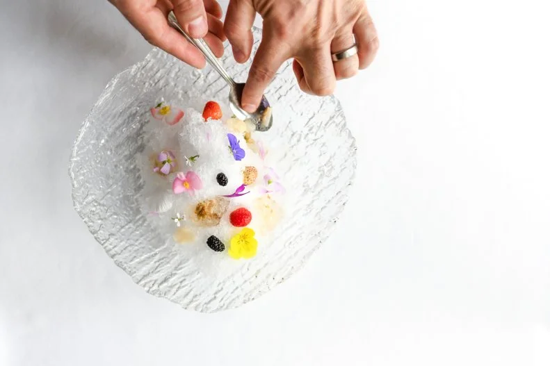 The team at this spa and hotel restaurant manipulate the shaved ice to be reminiscent of a winter snowball, the kind they used to toss around as kids. To do this they make shaved ice with a Japanese kakigori machine and top the ball of ice with frosted lemon rose germanium leaves that they grow on the restaurant’s farmland. The dish is finished with pickled blueberries, violet jam, honey, snow sugar and a little creme fraiche.