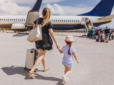 Young mother and her beautiful daughter boarding a plane.