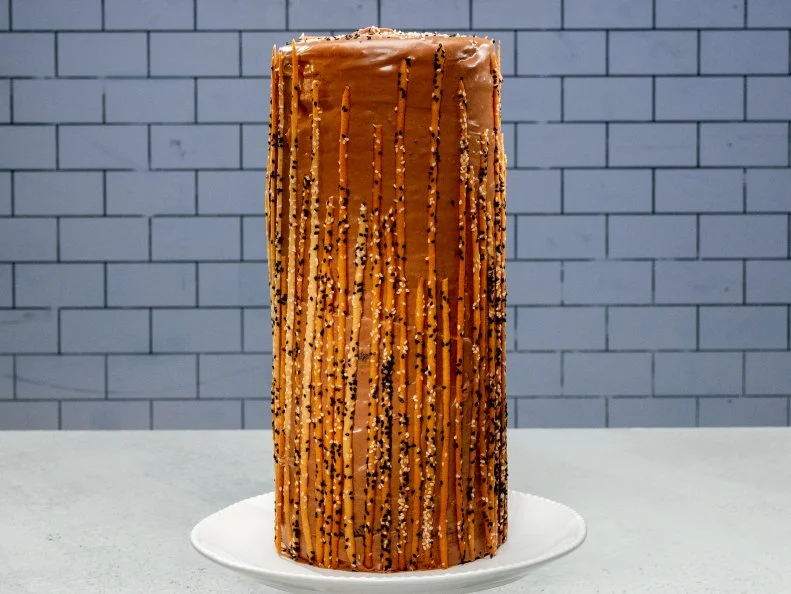 Contestant Jeffrey De Leon's cake is Black sesame genoise sponge, honey soaked almond jocund, caramel milk chocolate tahini ganache and sesame tuile, during the Master Challenge, as seen on Best Baker in America, Season 3.